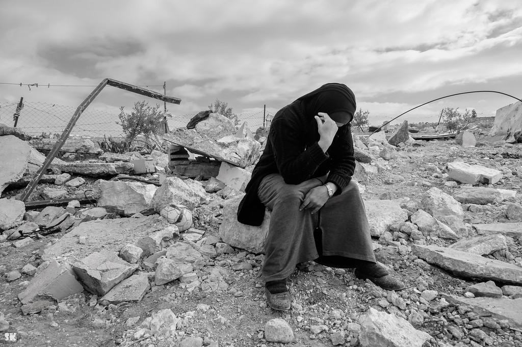 Woman sitting on the ruins of her house destroyed by Israel in Masafer Yatta January 2023
