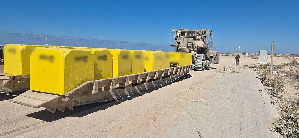 نصبوا على الجيش بالملايين: اعتقال 21 إسرائيليًا عملوا في غزة 2 جرافة للجيش تحمل مكعبات للإشارة للخط الأصفر، صورة توضيحية، المصدر: ويكيميديا